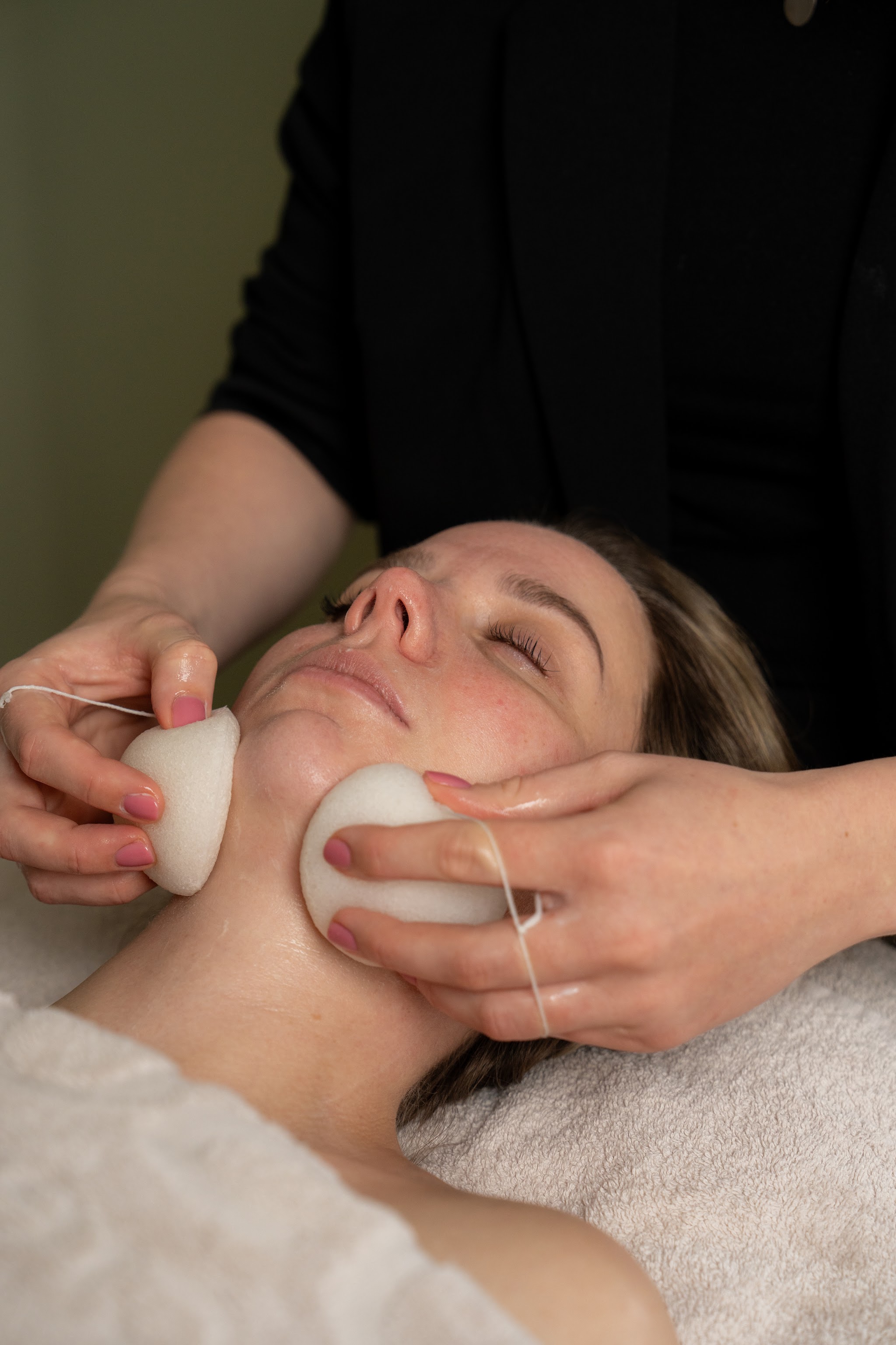 Facial met twee konjac-sponsjes langs wang en kaak